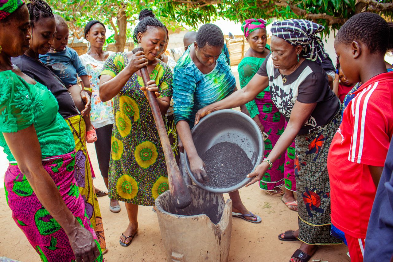 The Art of Drawing Readers In: Your attractive post title goes here A vibrant group of people working together in a traditional cooking setting outdoors.